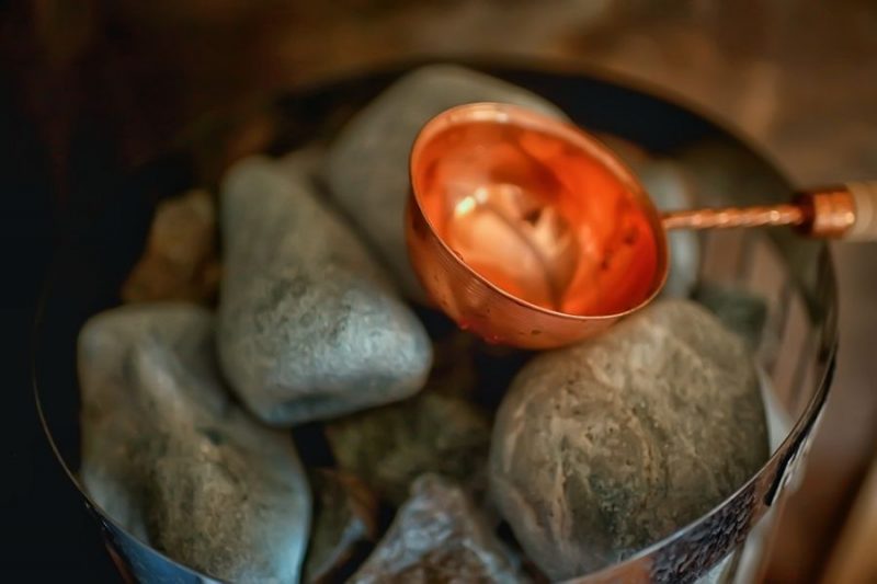 Koel water opgieten op de hete stenen zorgt voor stoom