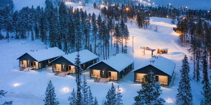 Pyhä en hiver avec les chalets illuminés, les remontées mécaniques et les pistes en arrière-plan