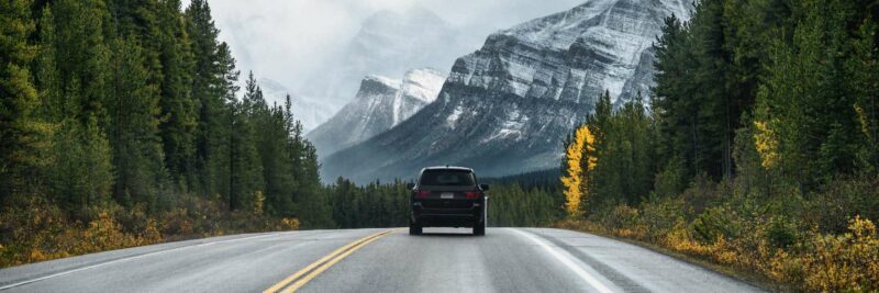 Zwarte auto rijdt de bergen - Nordic
