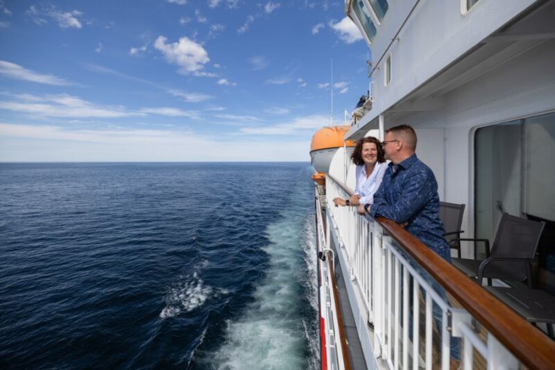 Couple sur le pont d'un navire Hurtigruten le long de la côte norvégienne Voyager avec Nordic, le spécialiste de la Scandinavie